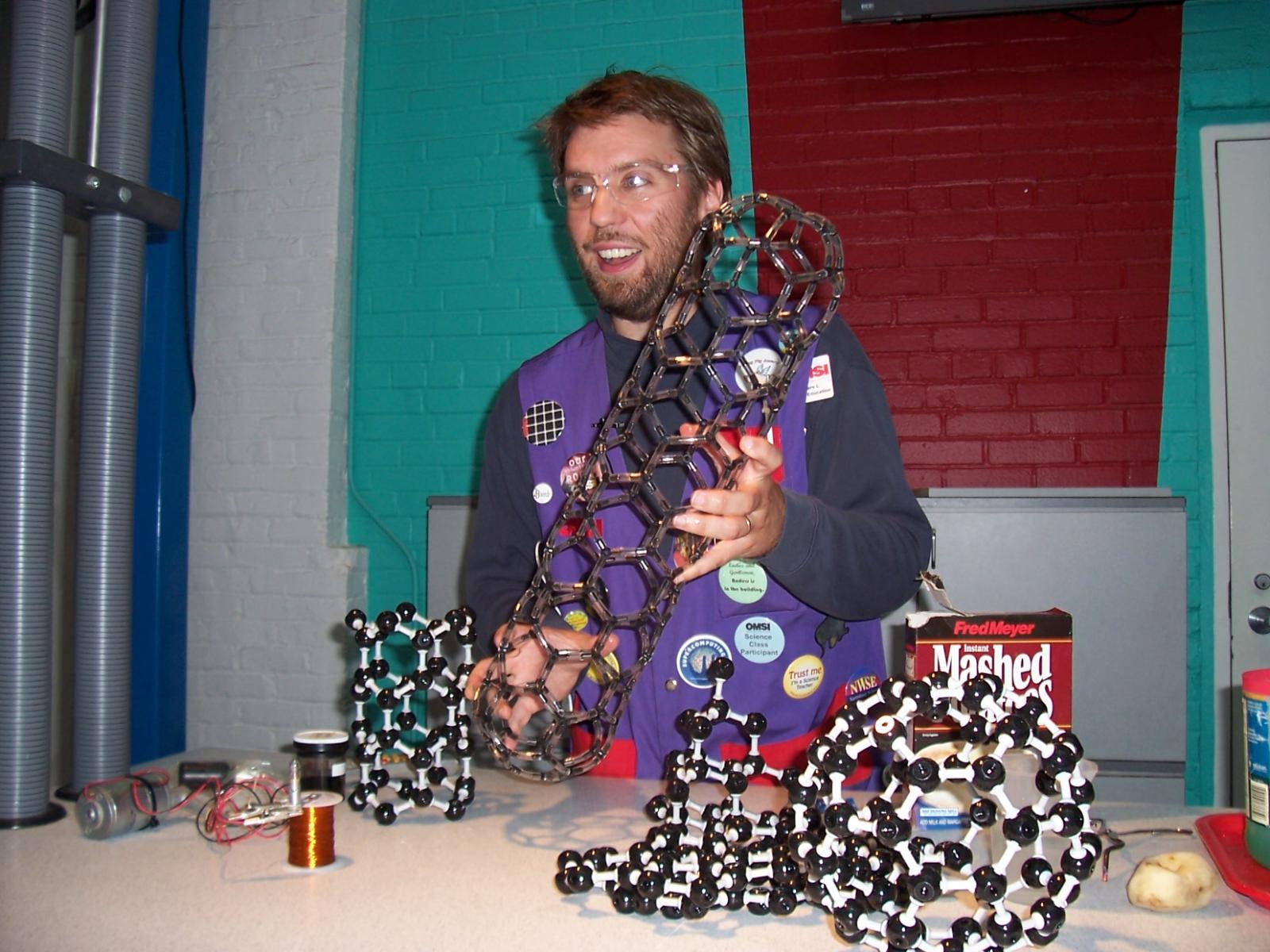 Facilitator runs a nanotechnology cart demonstration using atomic carbon models