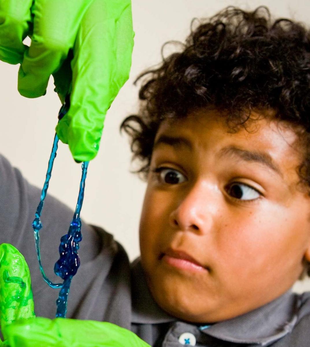learner with green gloves holds a string of blue slime