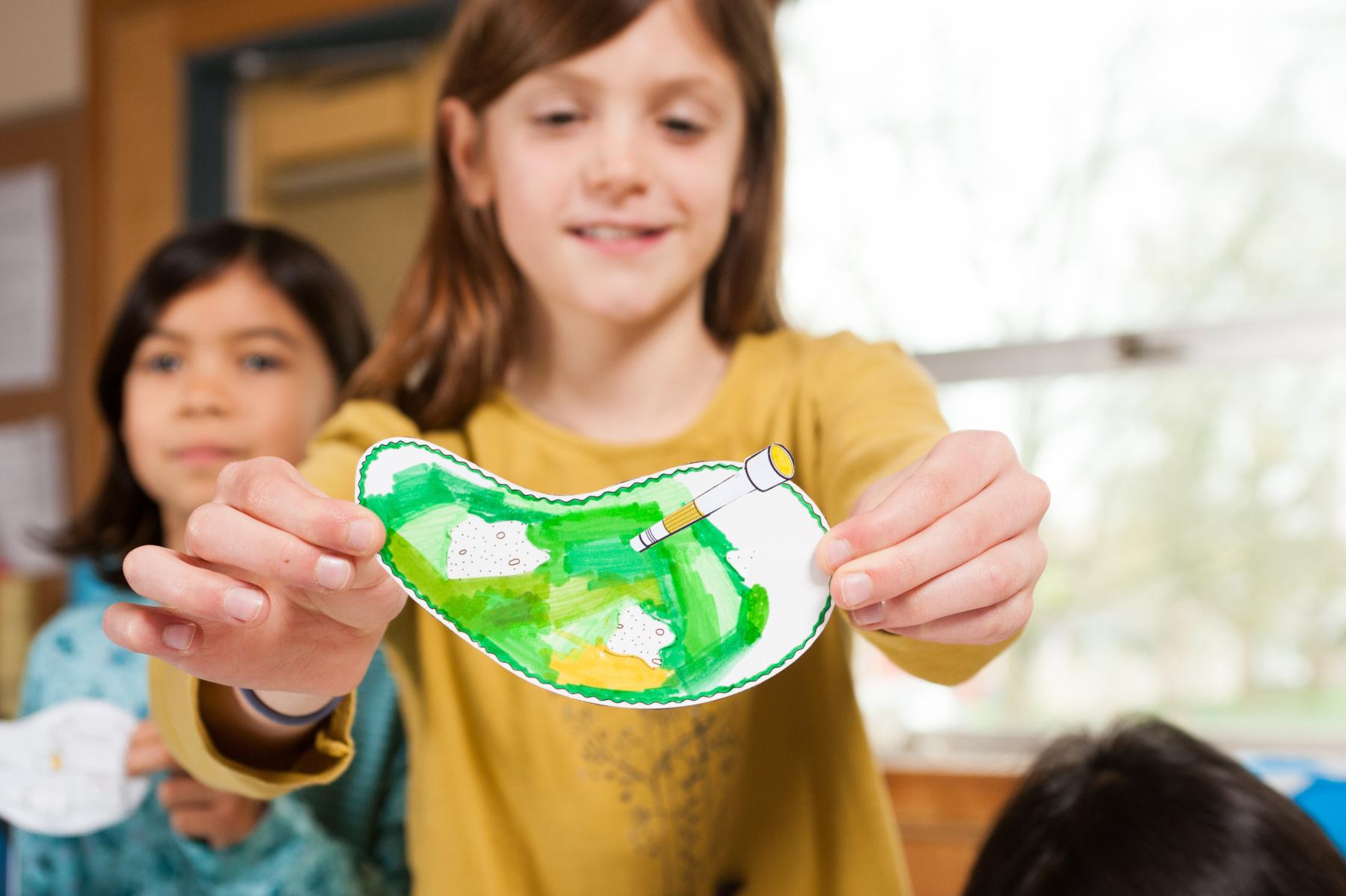 Young girl showing her hand-drawn synthetic biology organism