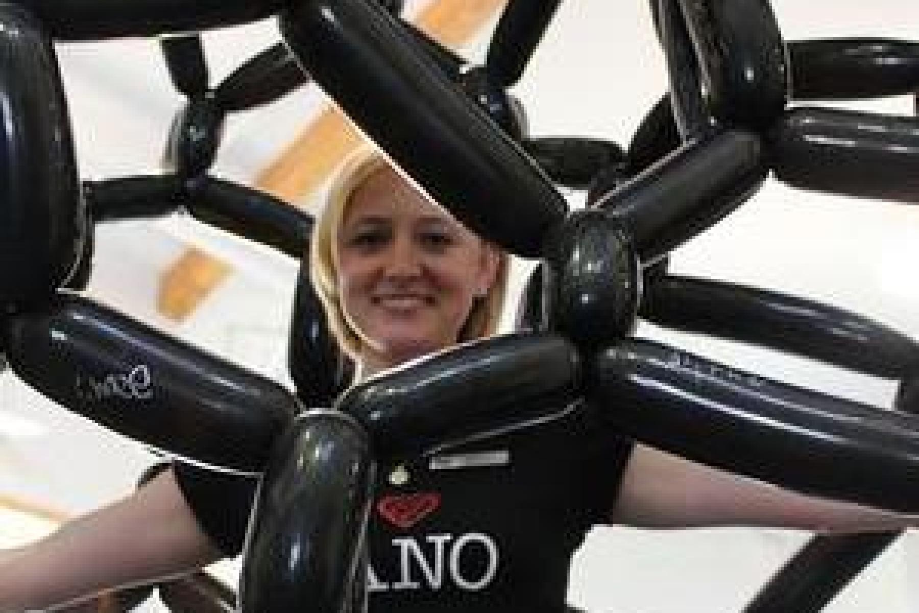 Person inside of a giant carbon nanotube model made of balloons