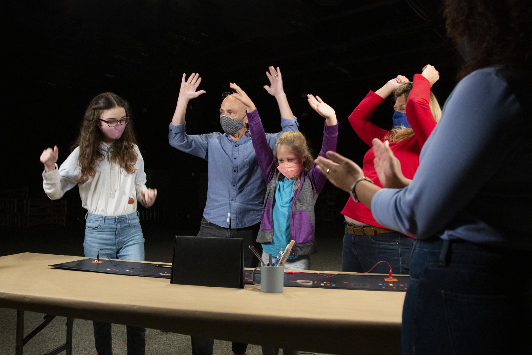 a family of learners celebrate after successfully completing the moon game