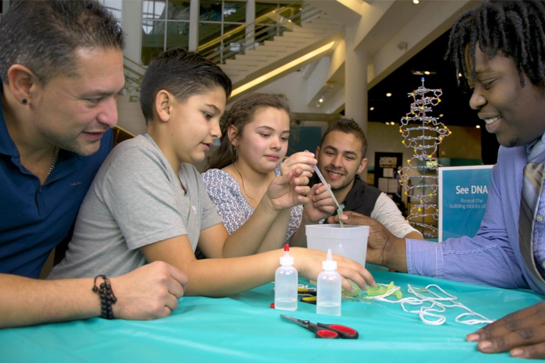 family and educator using a biology activity with squeeze bottles