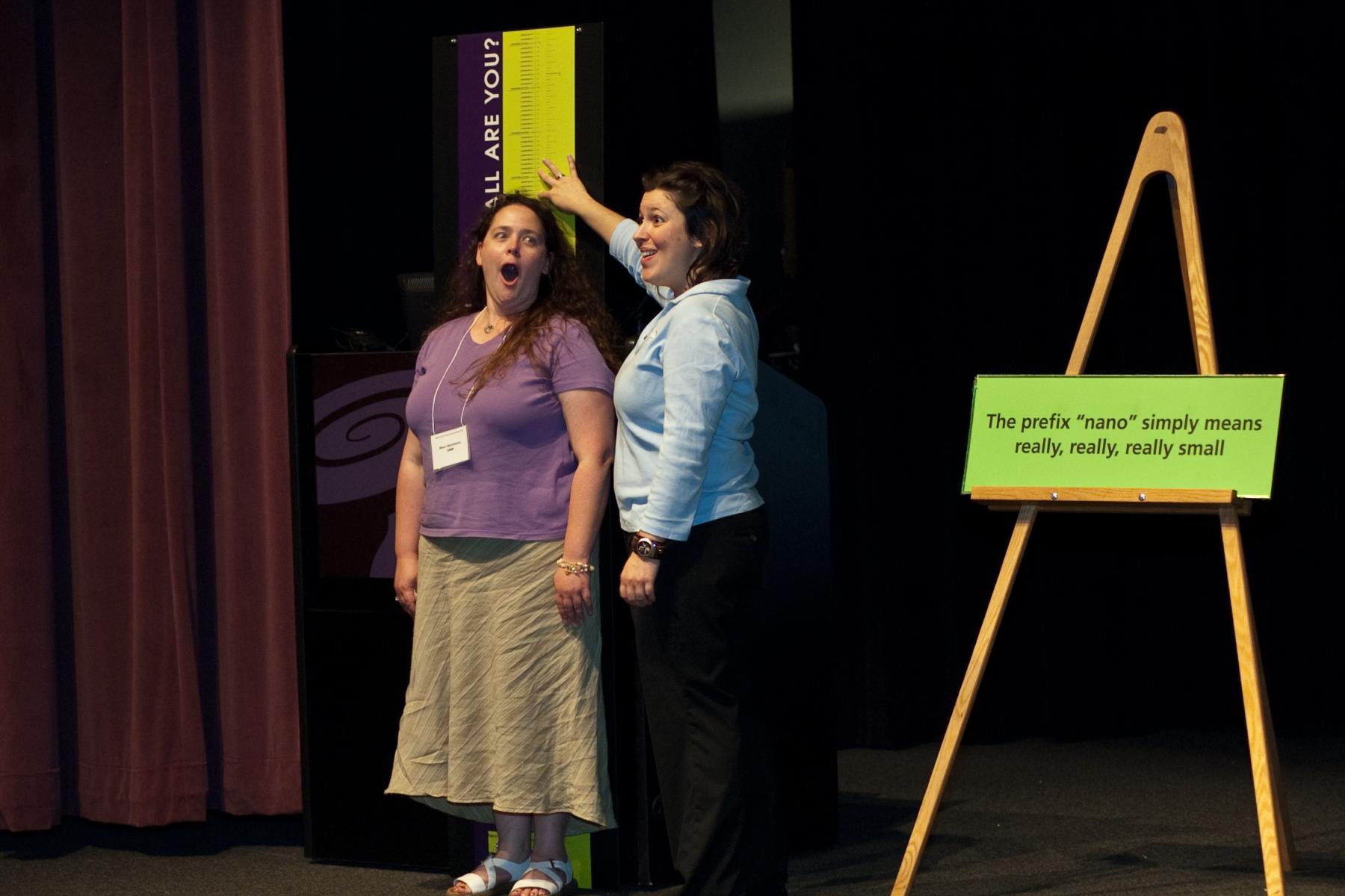 Educator measuring participant in Nanometers measuring on a stage