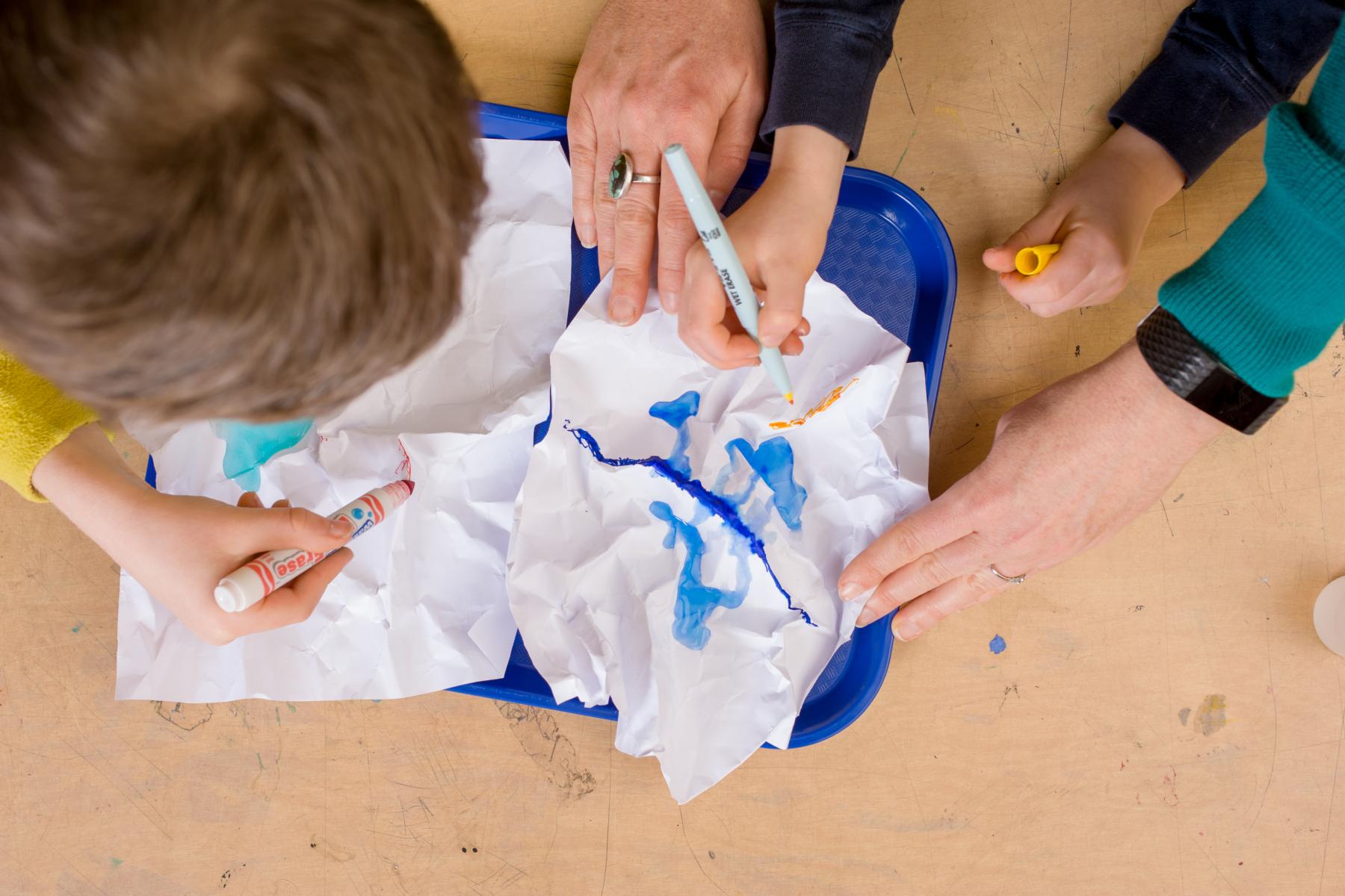 overhead photo of learners drawing on paper for paper mountains activity