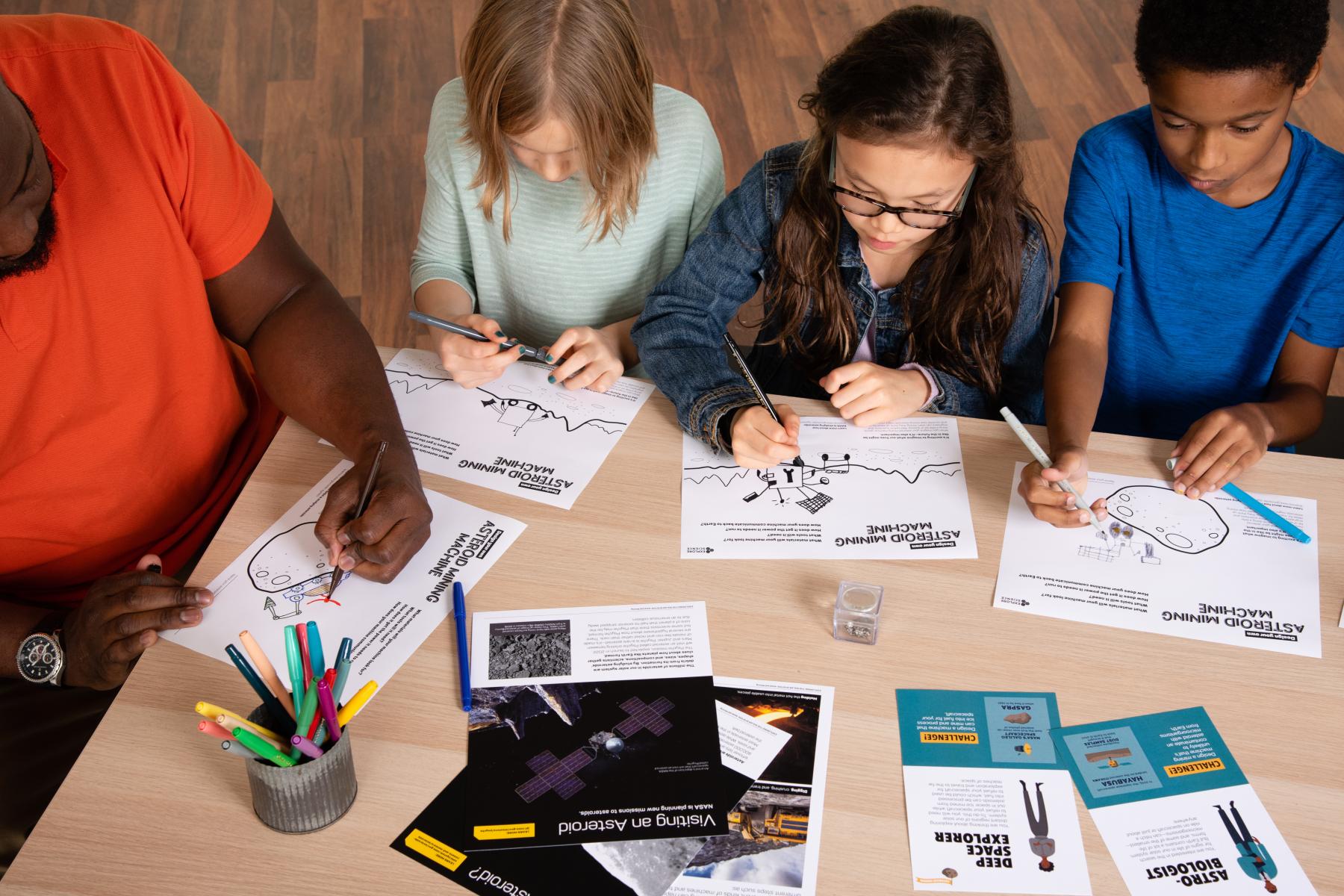 Learners and caregiver draw asteroid mining machines 