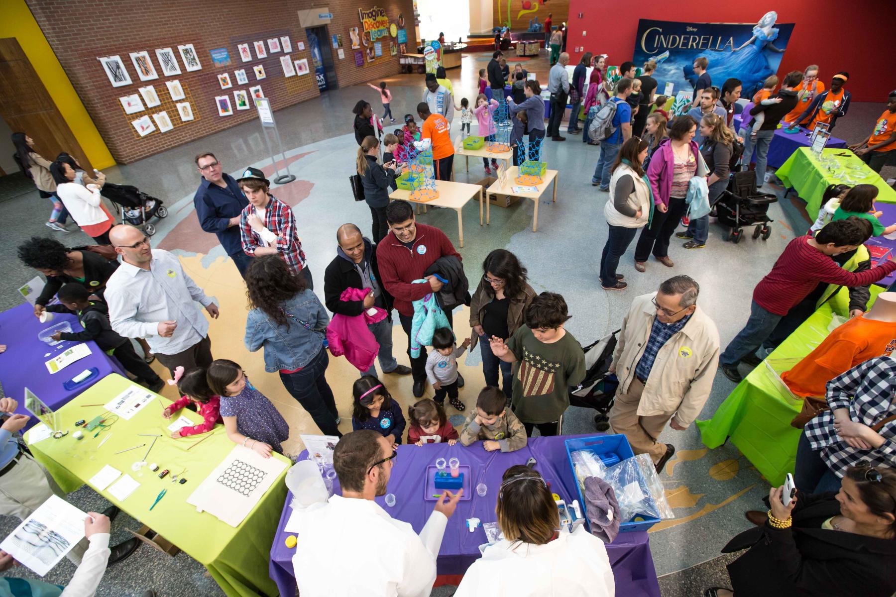 Large group at a museum event watching two experts conduct a demonstration 