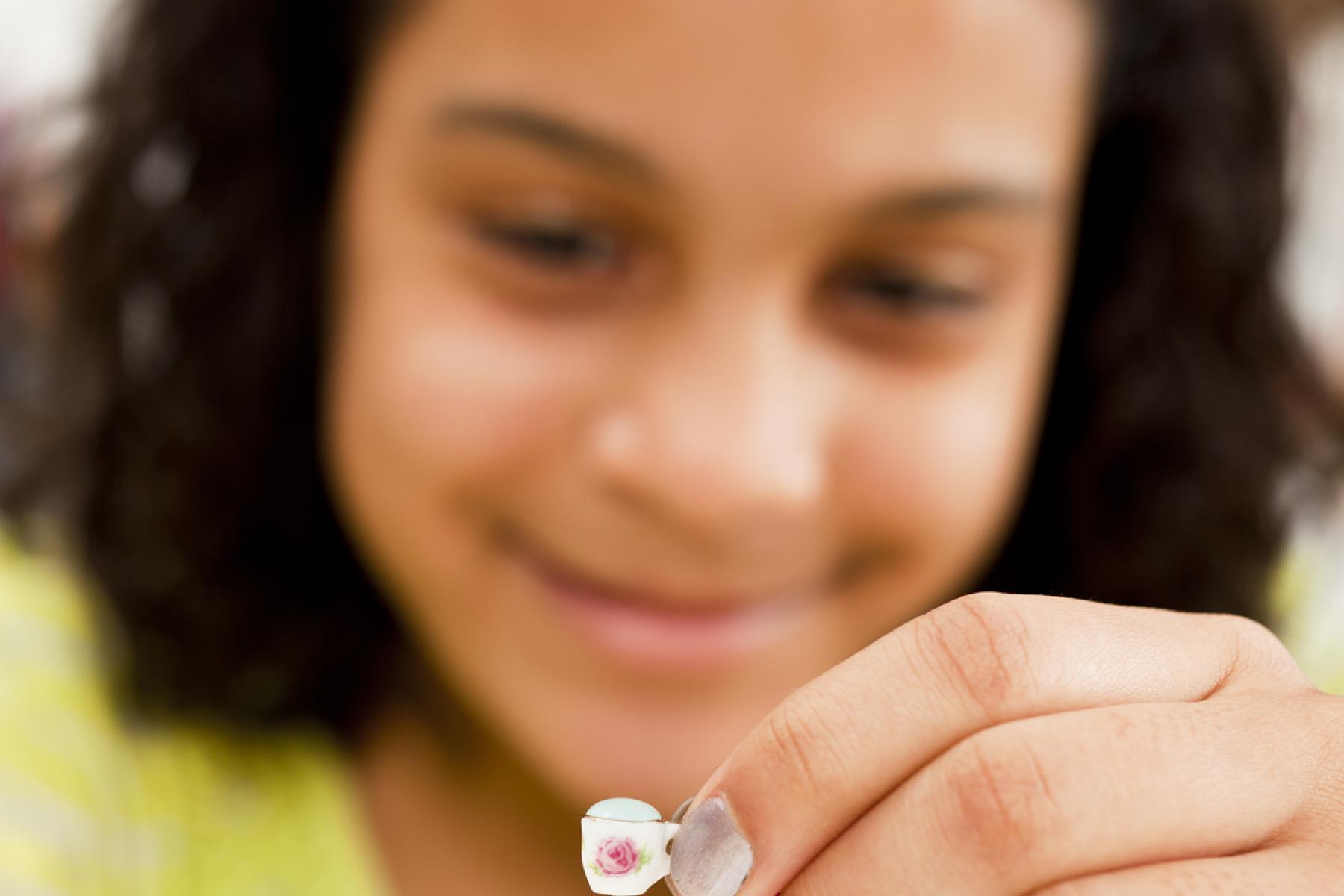 Photo of a learner closely observing water tension on a tiny teacup