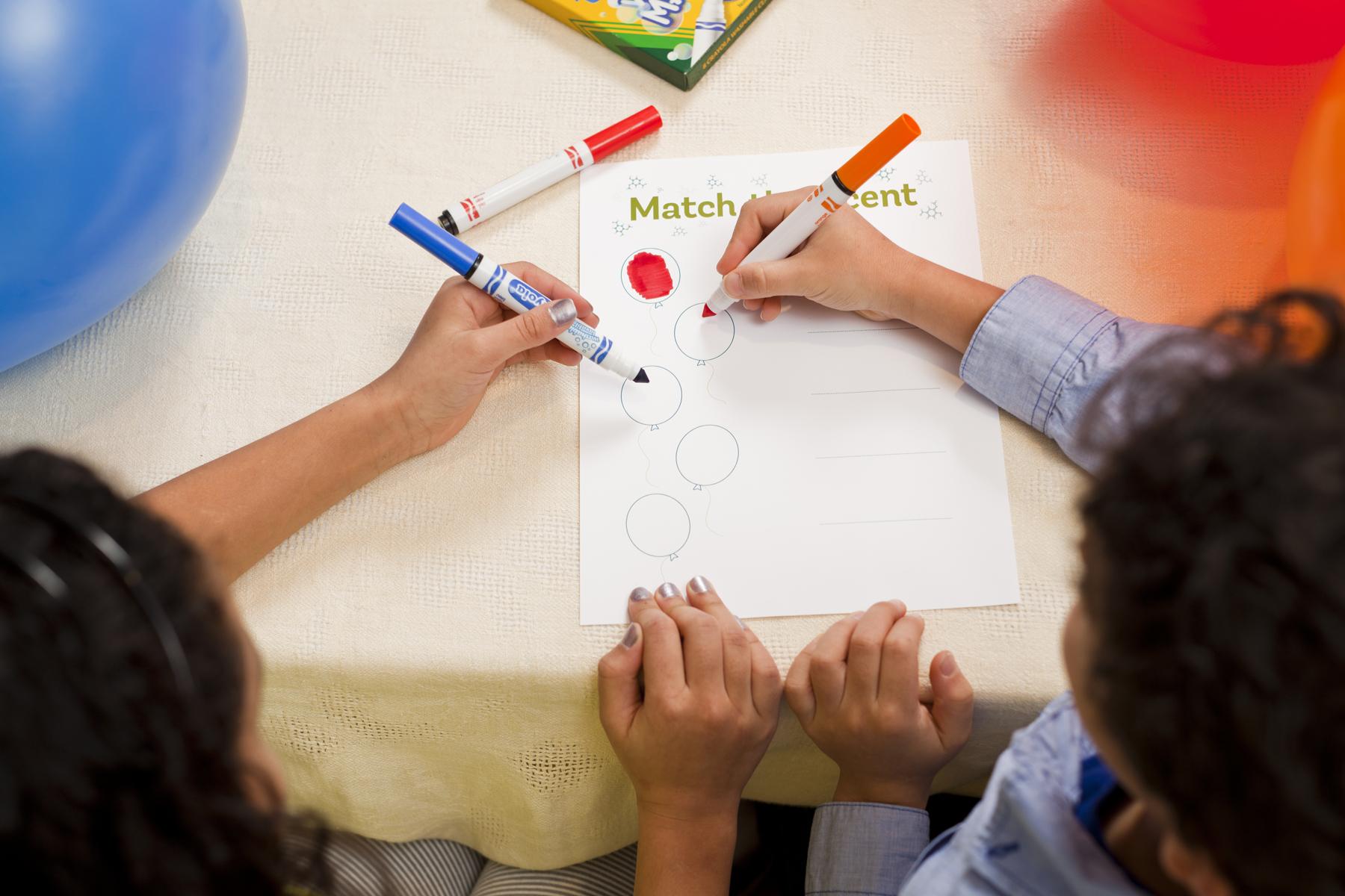 Two learners use markers to fill out a worksheet