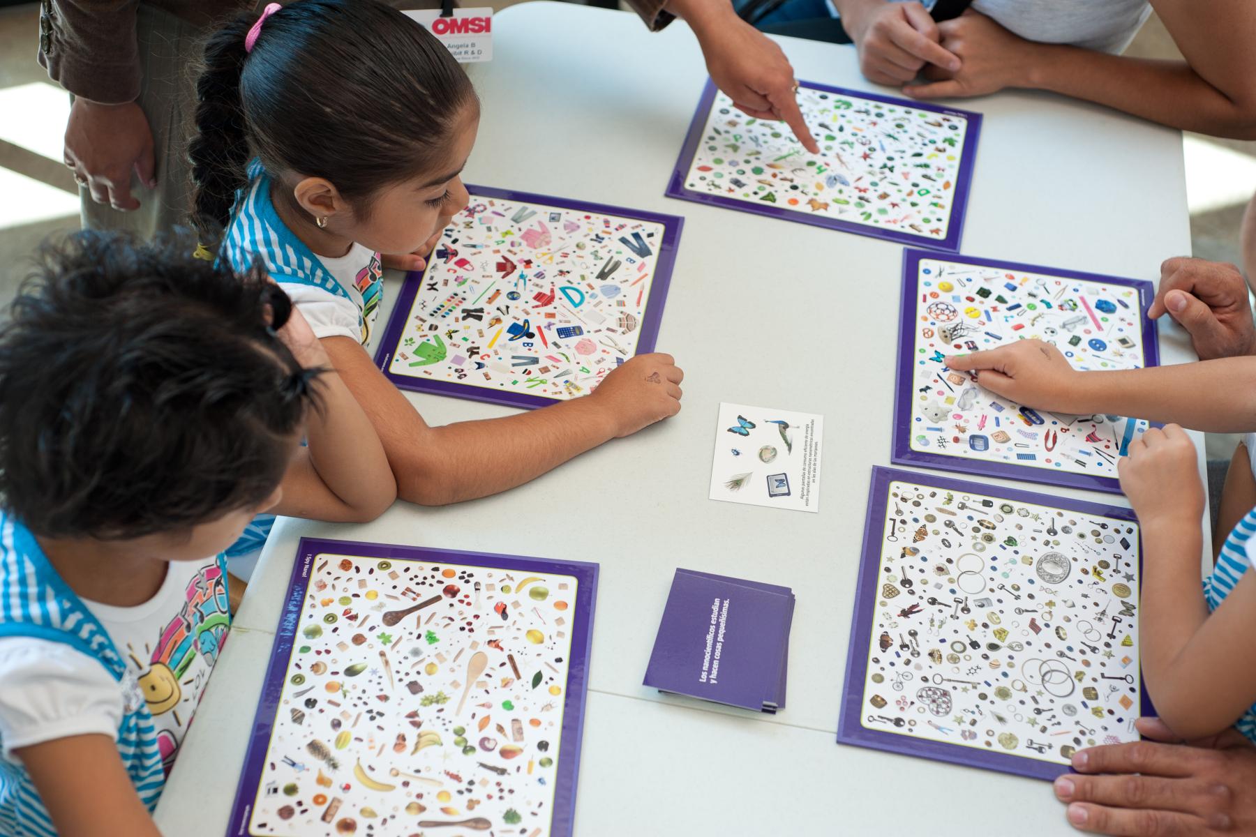 A group of learners scan their I Spy Nano mats for a particular object hidden in the photo