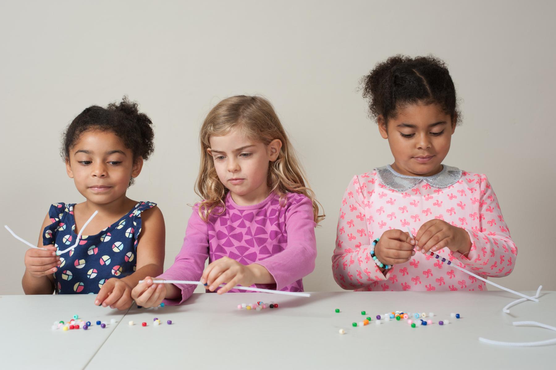 a group of learners build UV color changing beaded bracelets 