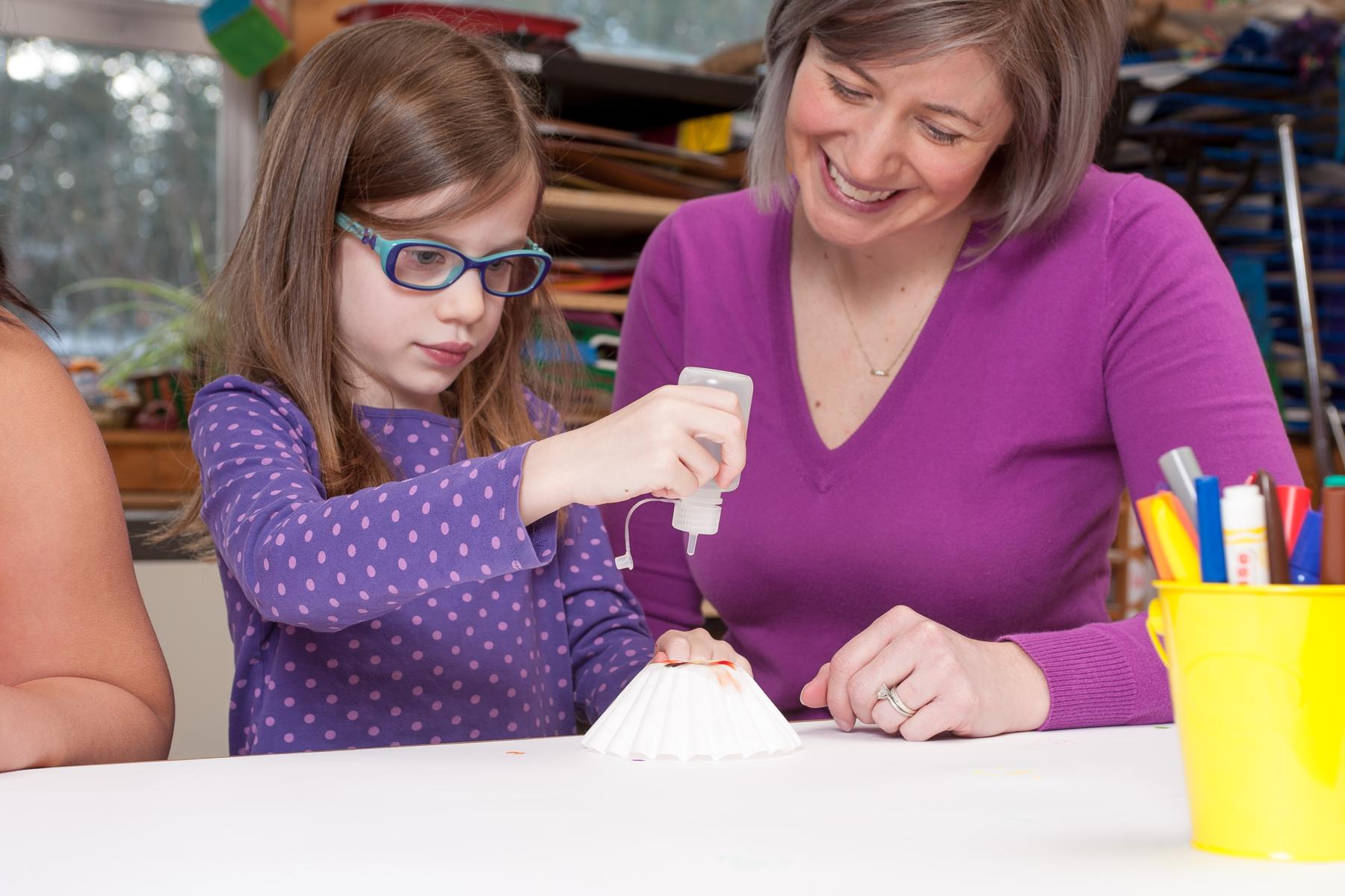 A young learner drips water onto a coffee filter to reveal ink diffusion