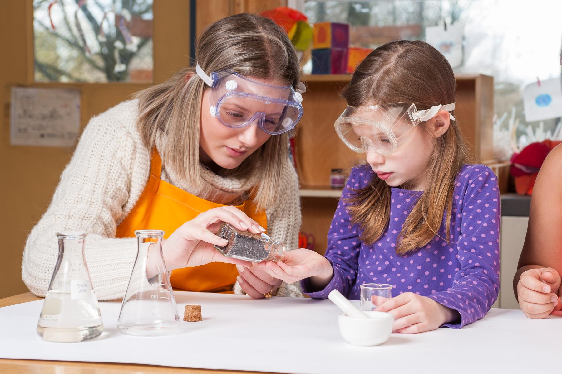 A facilitator and a learner measure out natural dye bug fragment