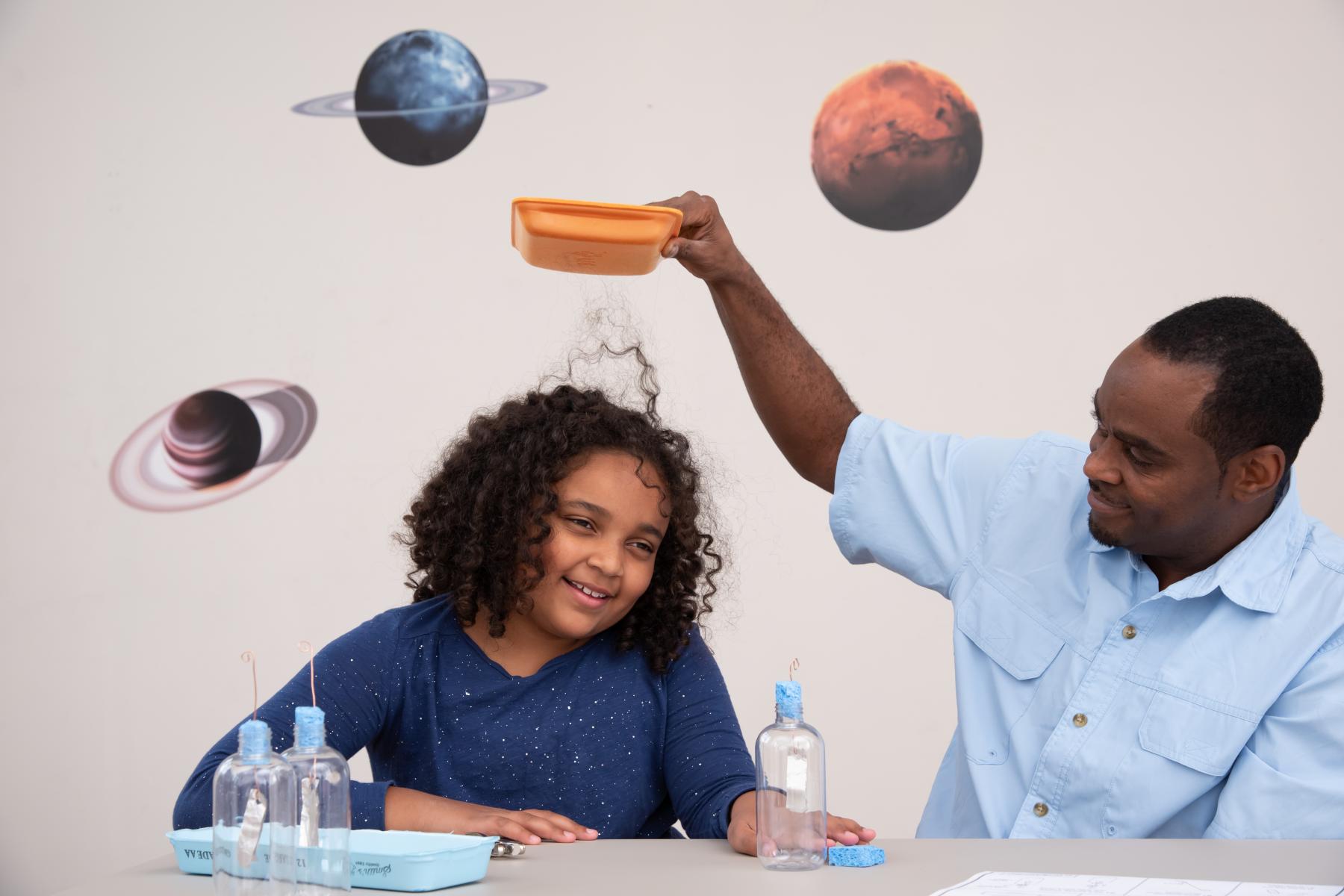 Family demonstrates static electricity on daughter's hair