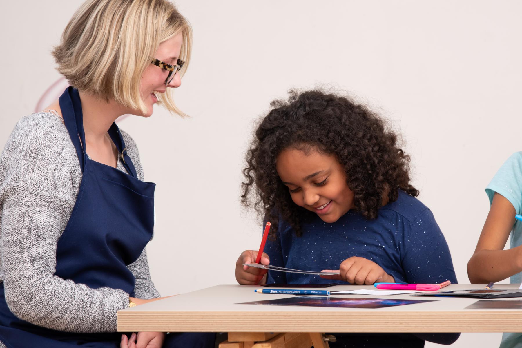 A facilitator and learner use a color filter to take a closer look at an image