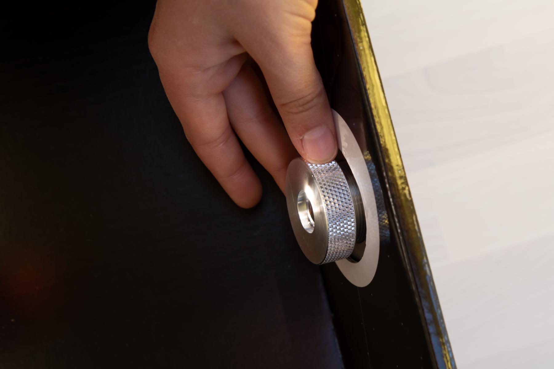 A hand is adjusting the focal point dial in a solarscope 