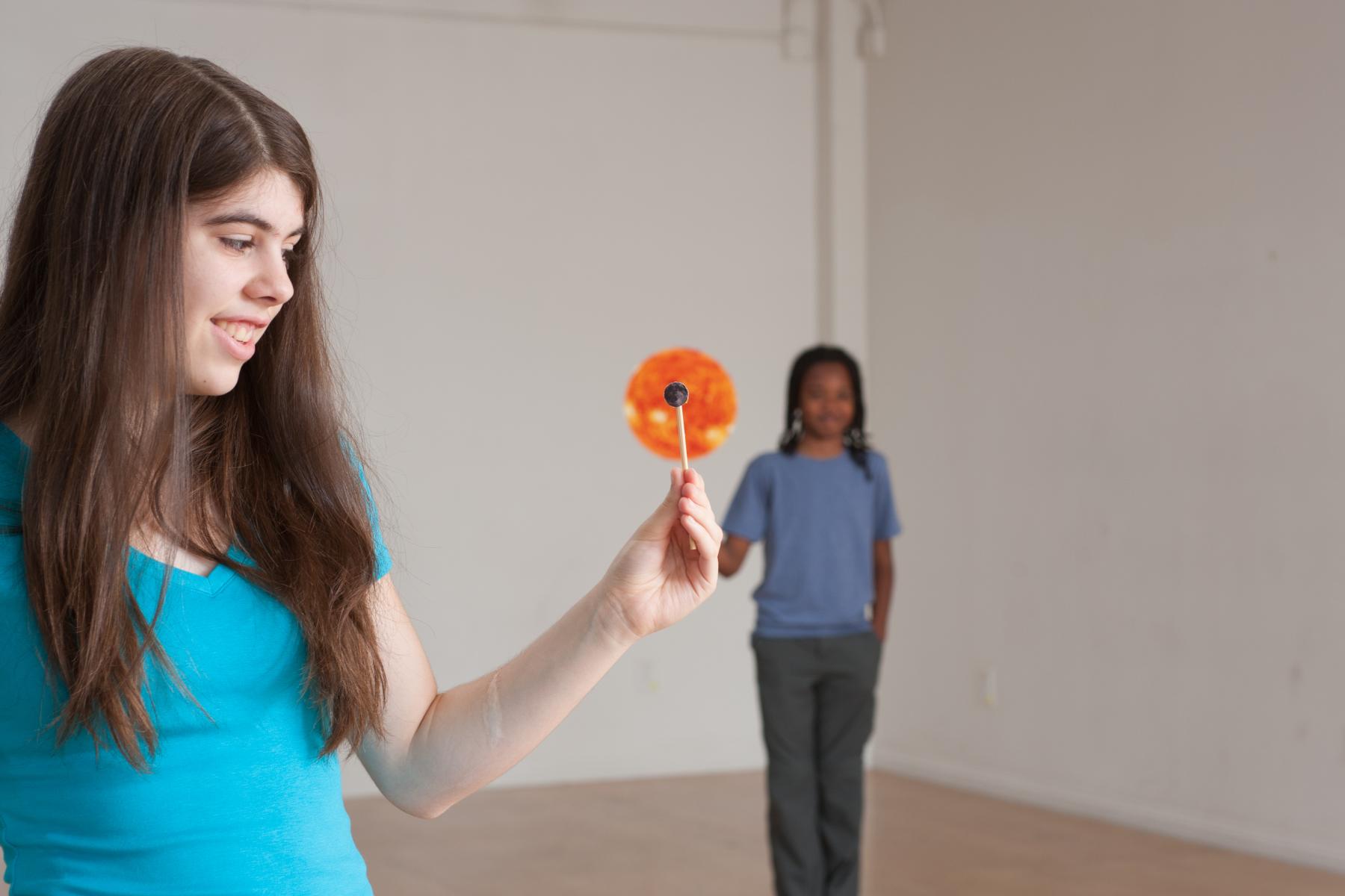 Female participant aligns a Moon model with a model of the sun