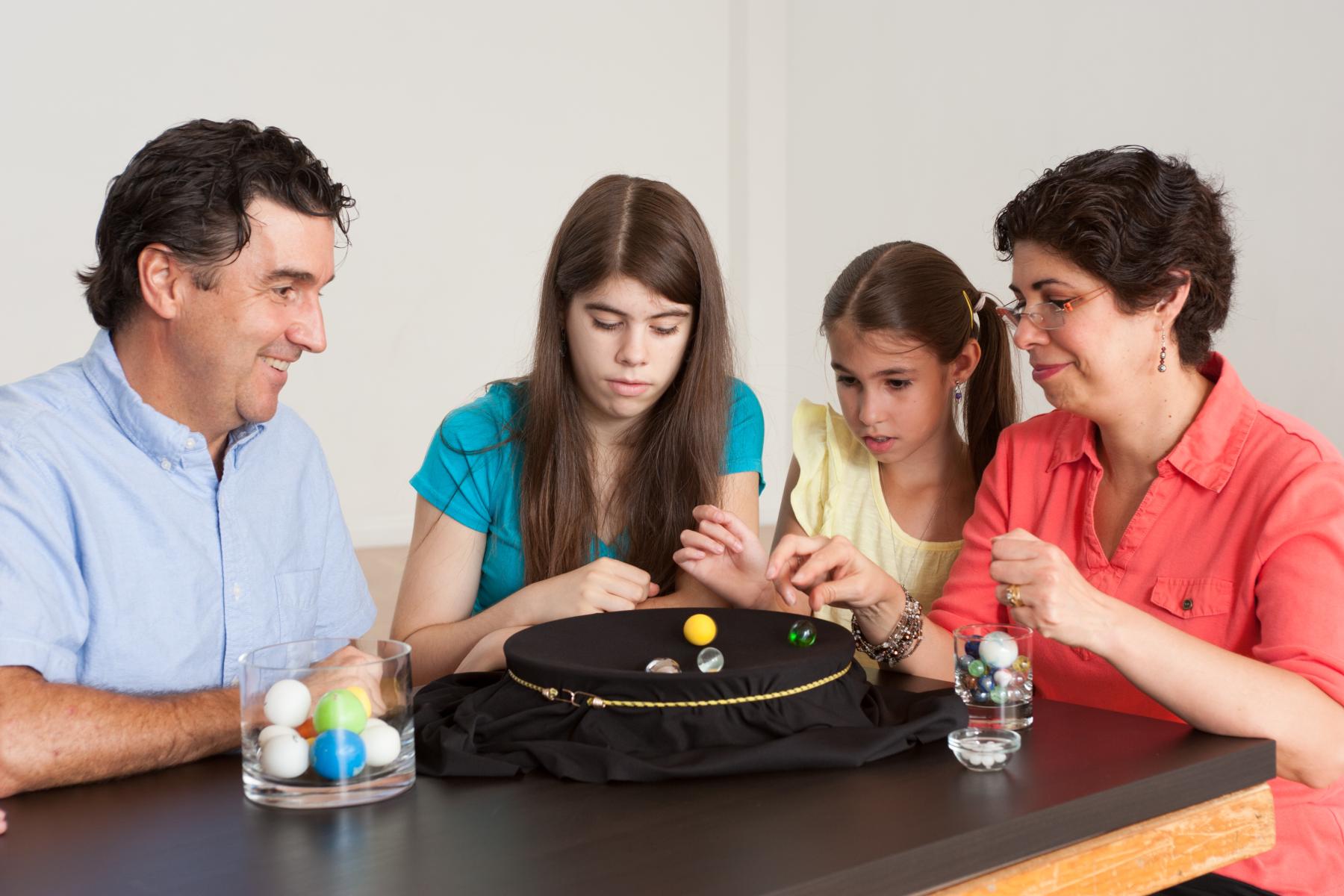 a family of learners watch spheres "orbit" in a "gravity well"