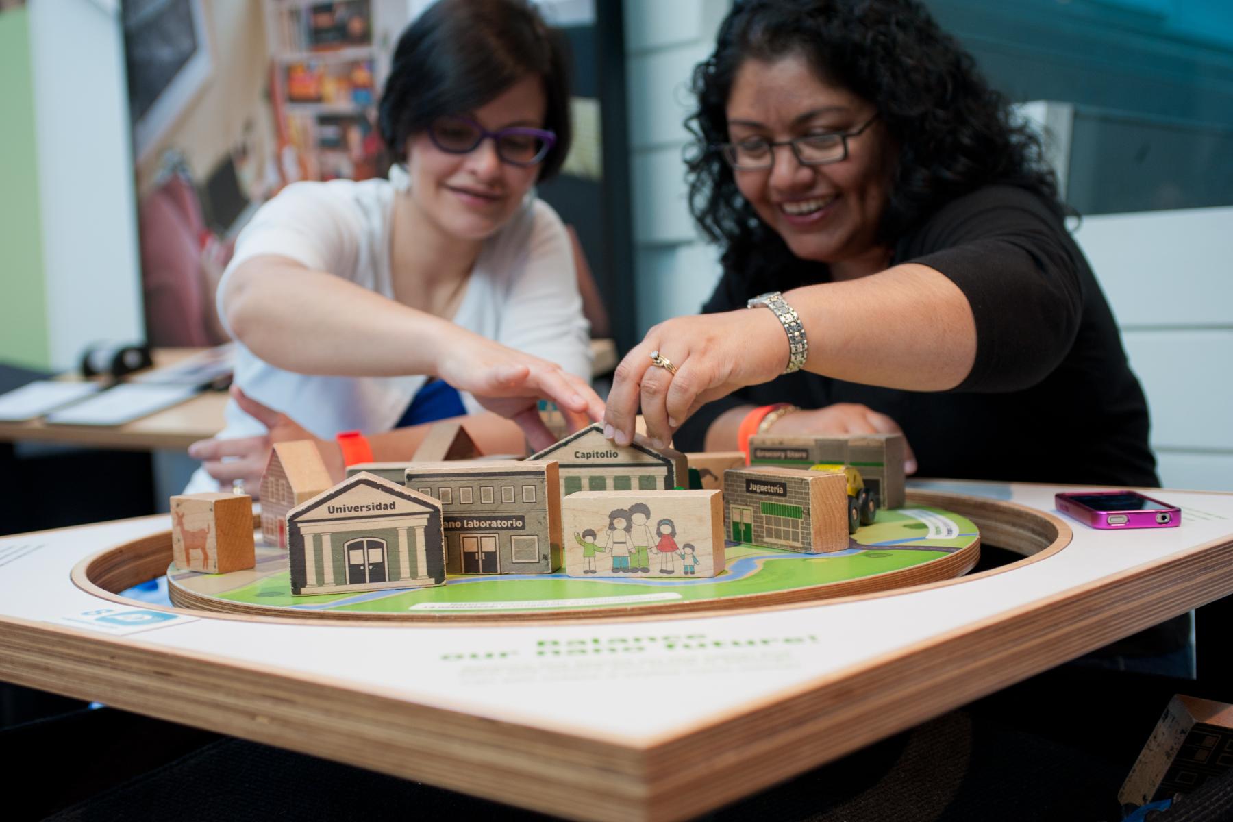 two adult learners try to balance the tippy table