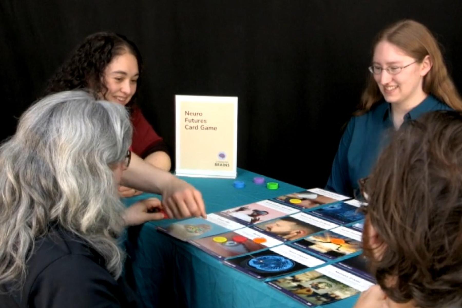 Players voting for cards on a tabel with token while a facilitator watches