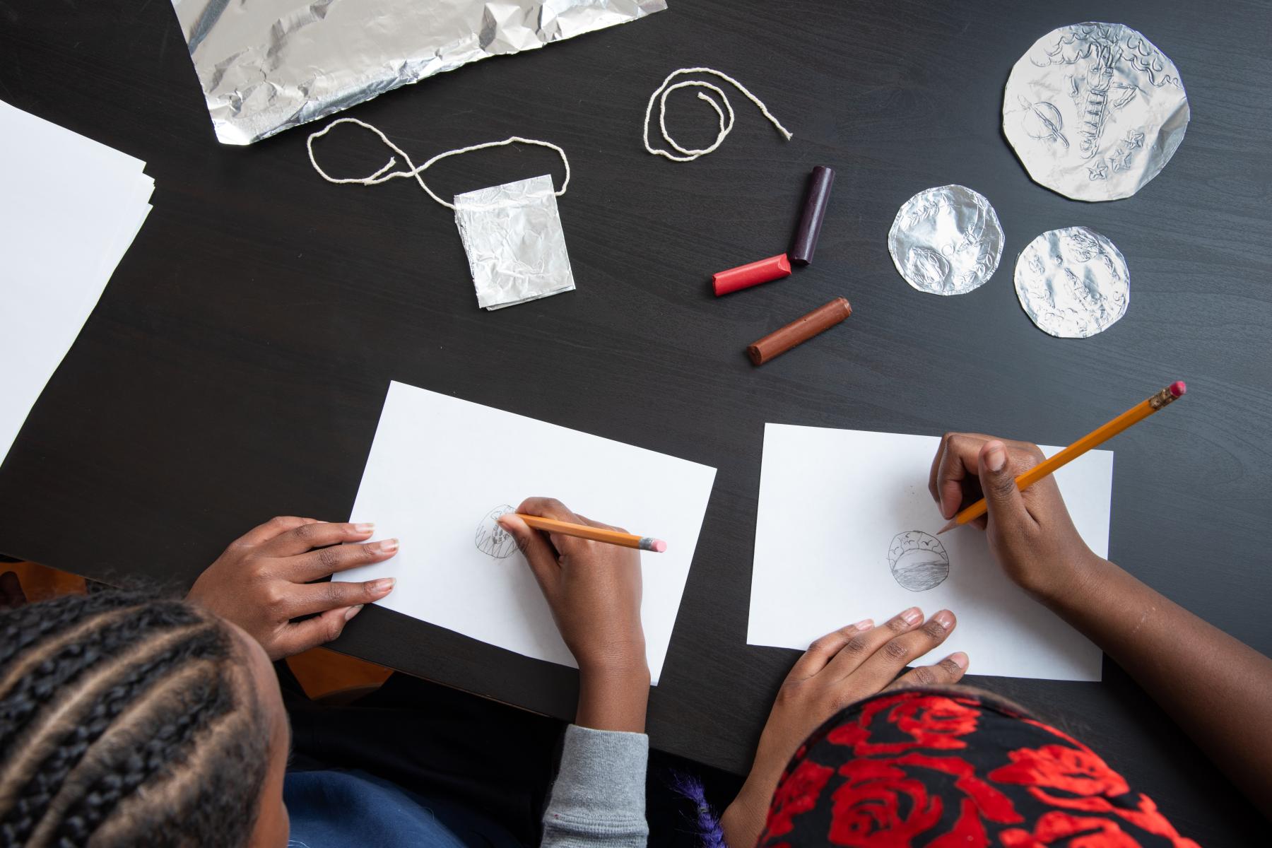 Voyage through the Solar System Space Souvenir two children designing a medallion 