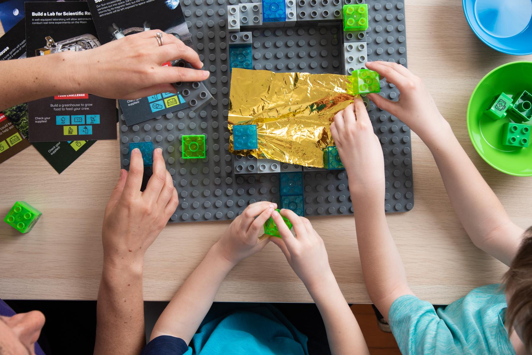 Voyage through the Solar System Build a Moon Base Camp learners using building bricks 