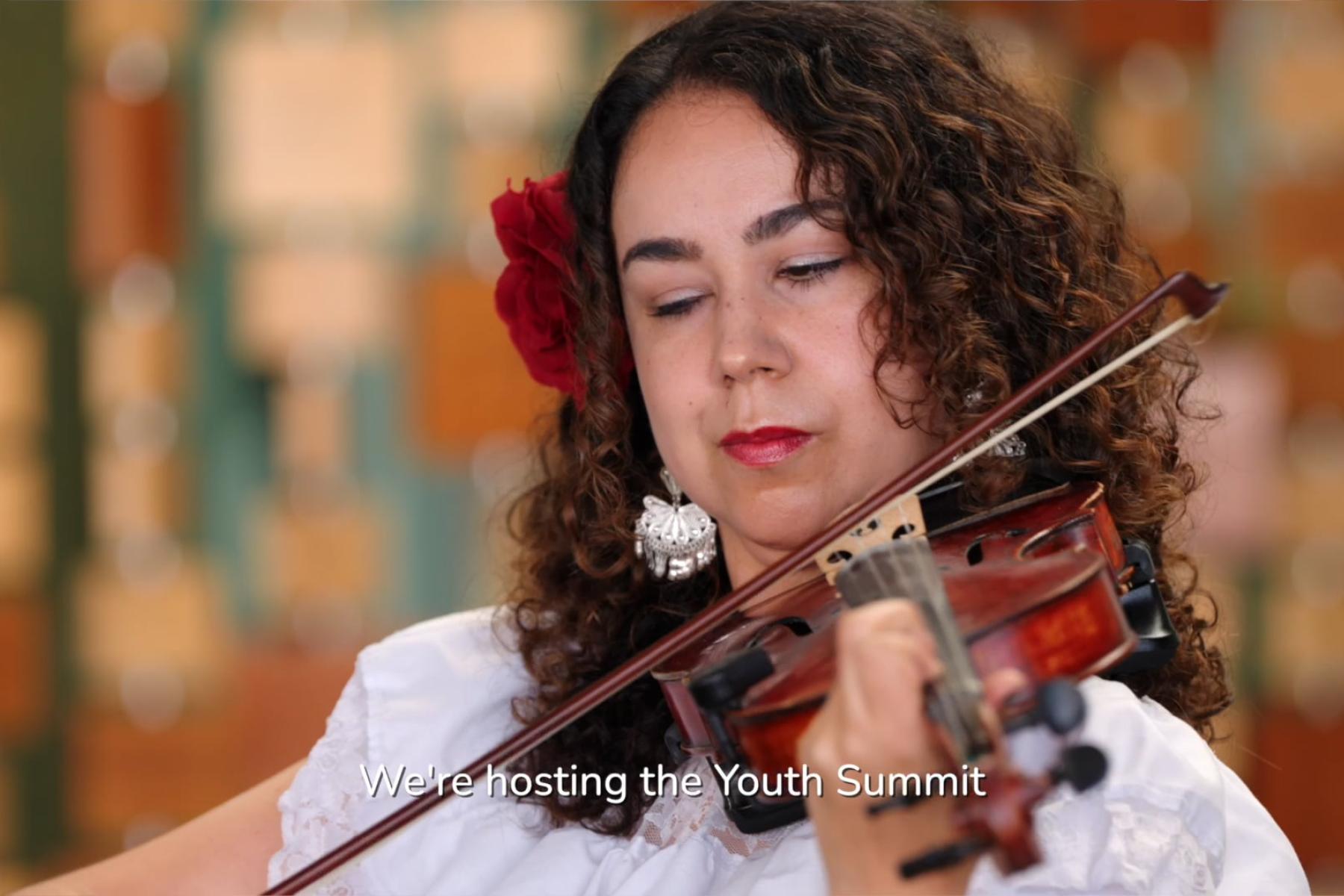An individual from the shoulders up is intently playing a violin.