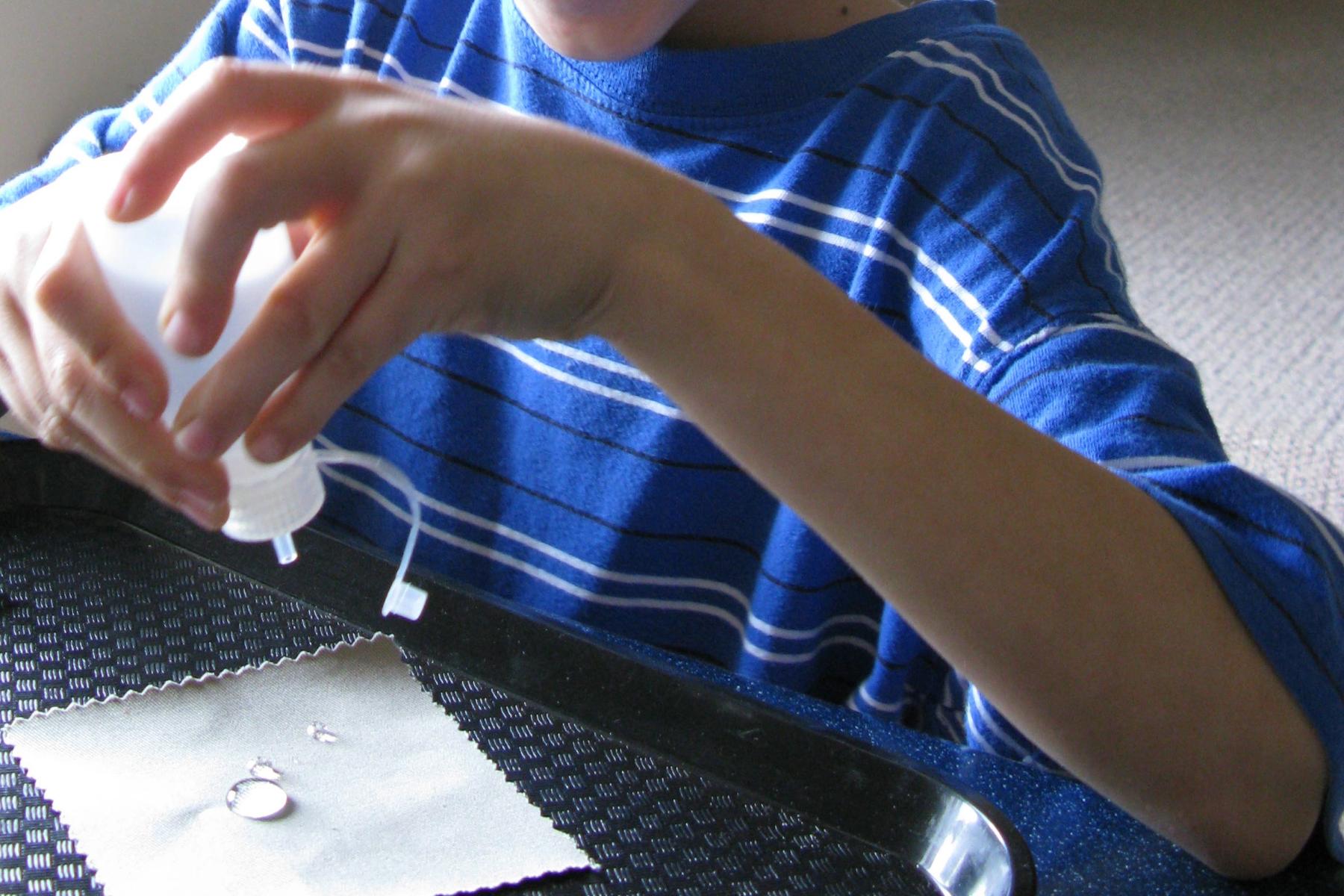 A child dropping water on a piece of fabric for the Nano Fabrics activity