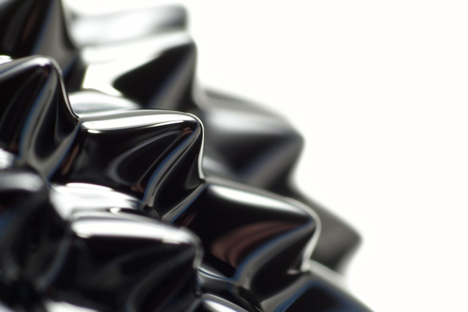 The surface of ferrofluid which is black, spikey (due to a magnetic field) and semi-glossy.