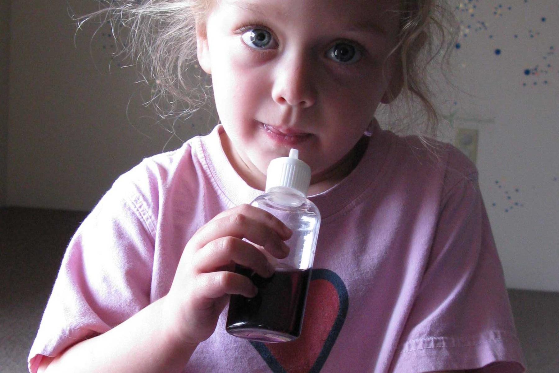 A learner sniffs a scent solution from a squeeze bottle 