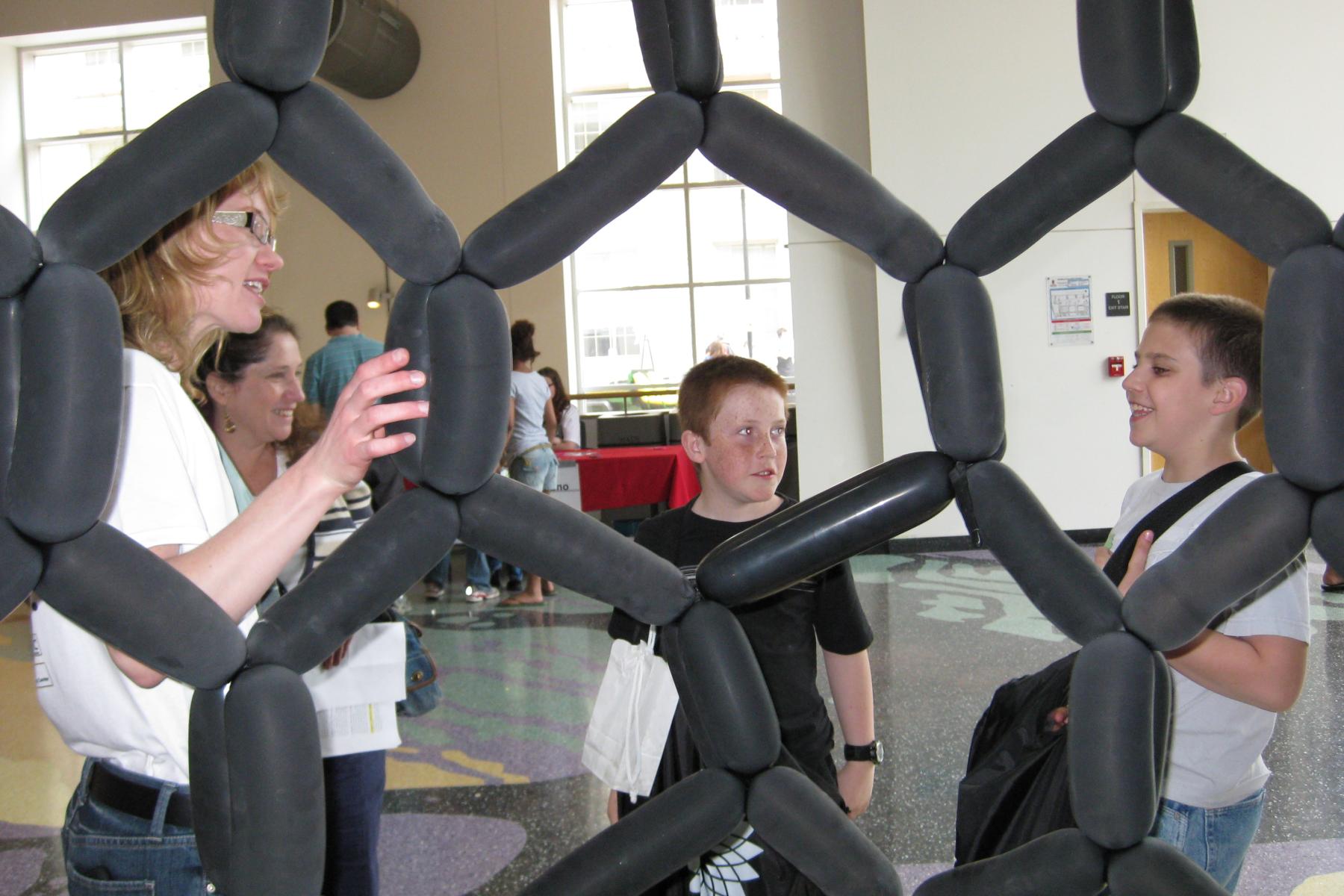 People discussing a balloon model of a carbon nanotube