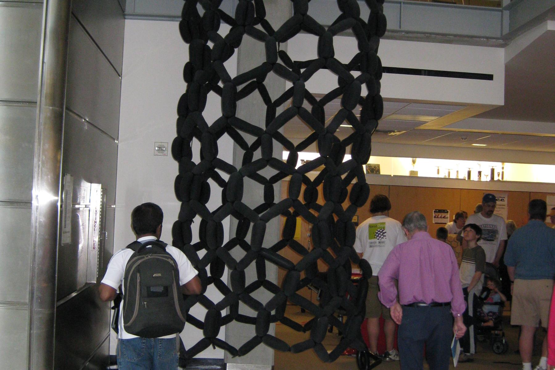 A long balloon model of a carbon nanotube hanging from the ceiling.