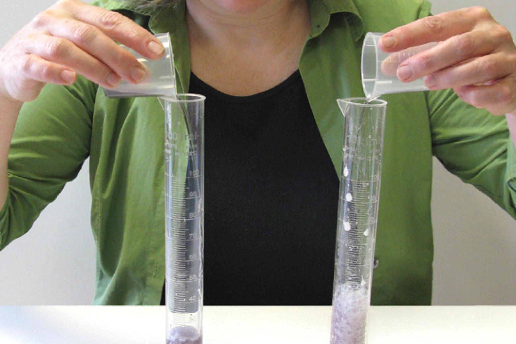 A person pouring alka seltzer into two test tubes and the seltzer reacts and forms bubbles in the Exploring Properties - Surface Area activity