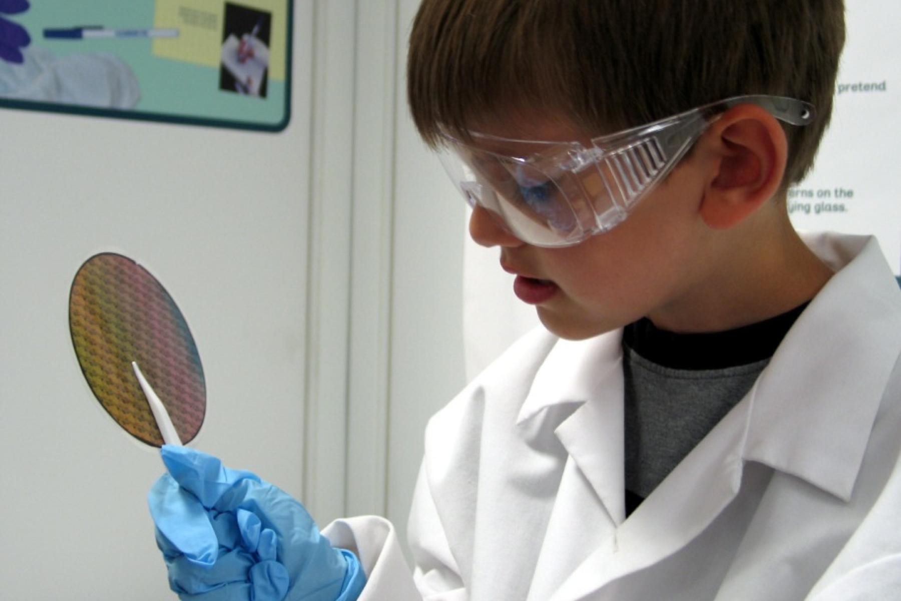 Little boy looking at a silicon wafer in the NanoLab exhibit