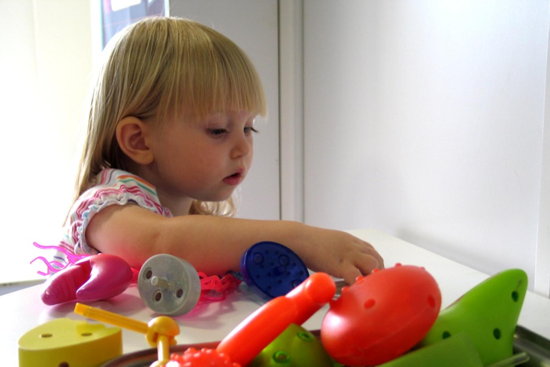 A little girl sorting various colorful plastic objects in the Fact or Fiction? exhibit