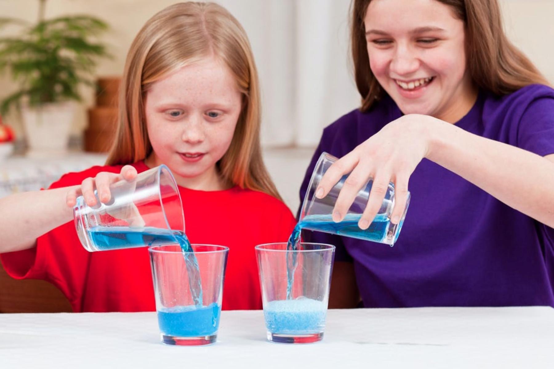 Girls pouring liquid into cups using DIY Nano Fizz activity