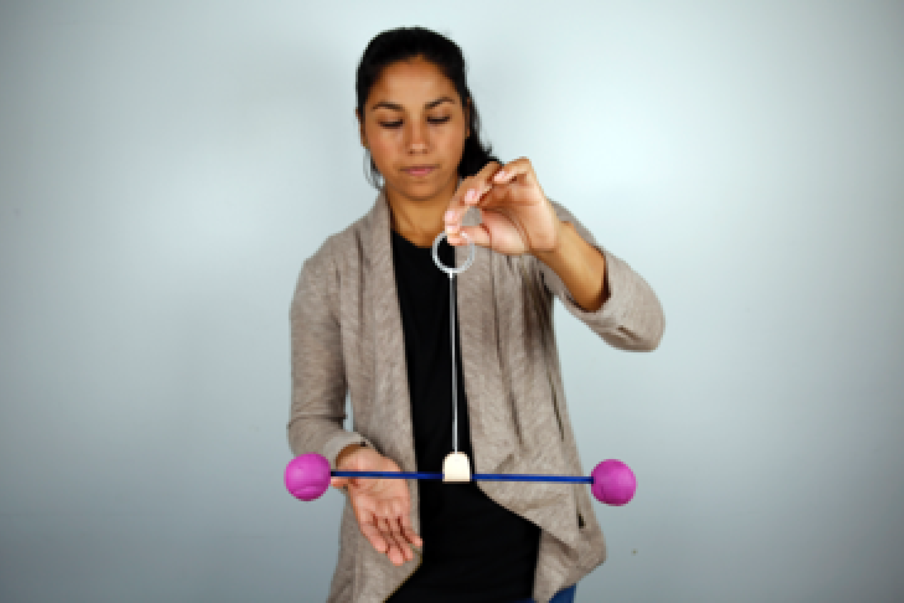 Photo of a learner spinning two clay objects on a suspended stick