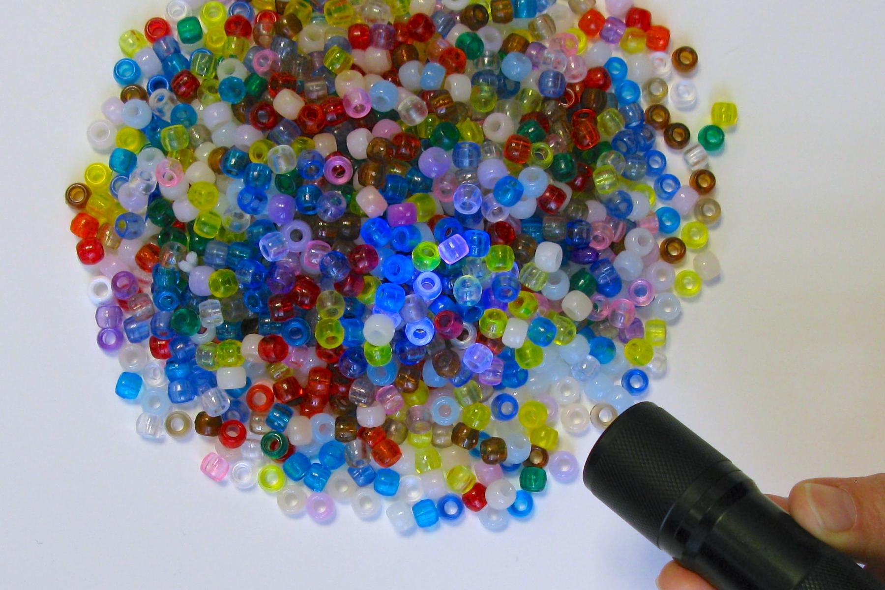 Light shining on colored beads in NanoDays Exploring Properties - UV Bracelets 