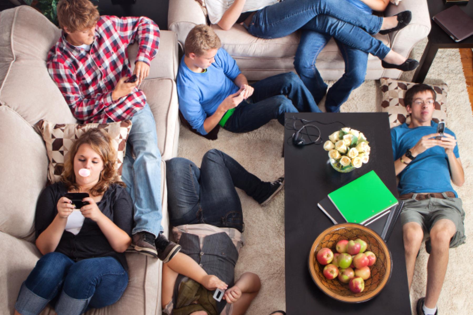 Stock photo of a group of people laying on couches and the floor