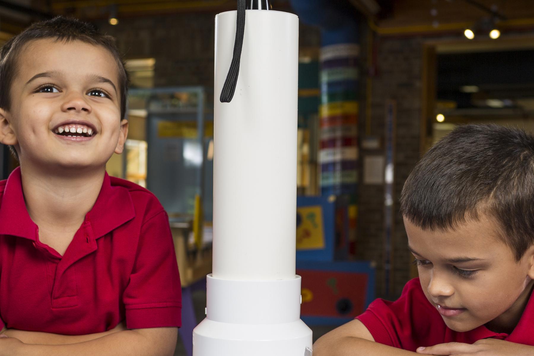 Two kids using a model Transmission Electron Microscope