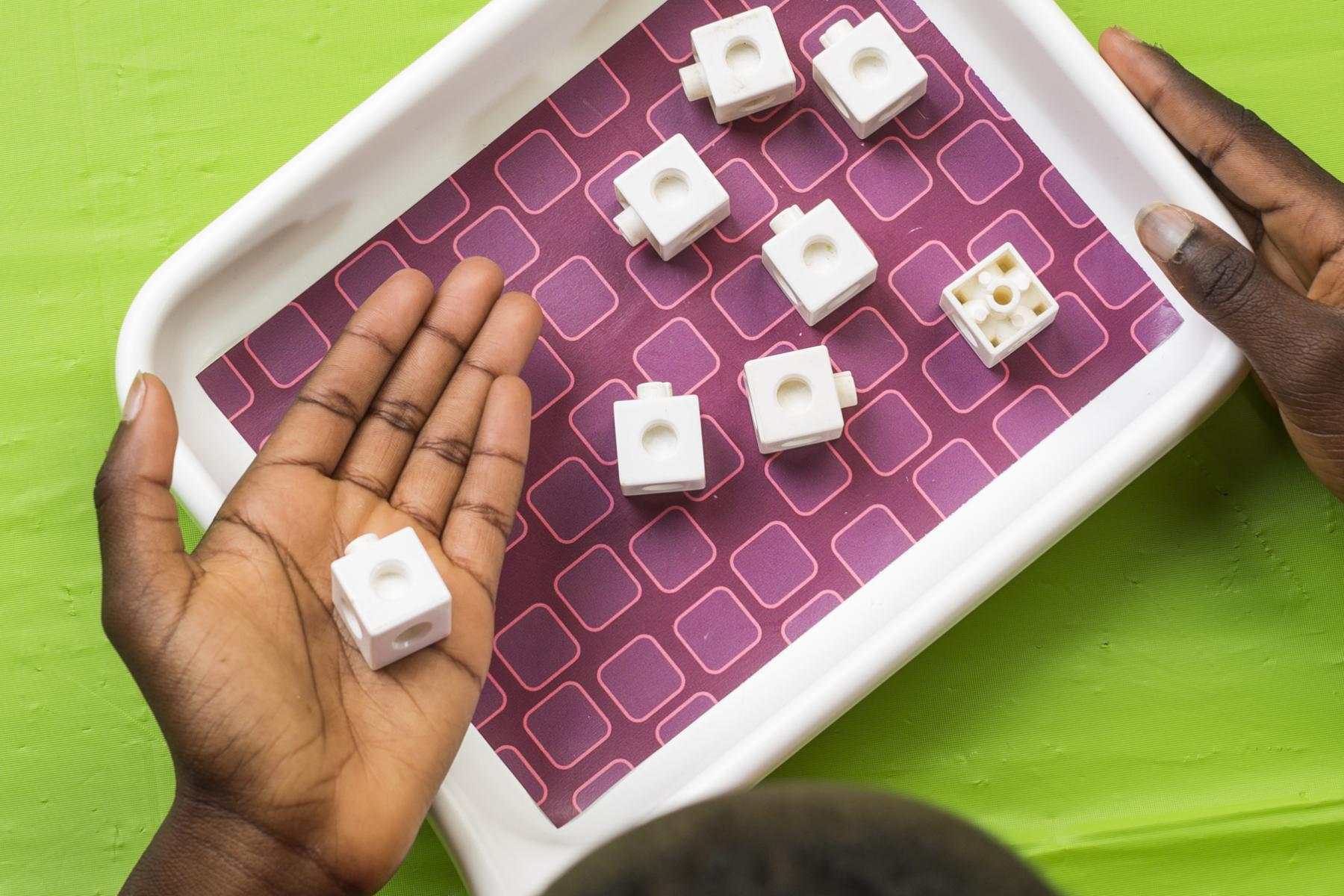 Person exploring NanoDays Nano Food activity holding snap cube pieces in hand