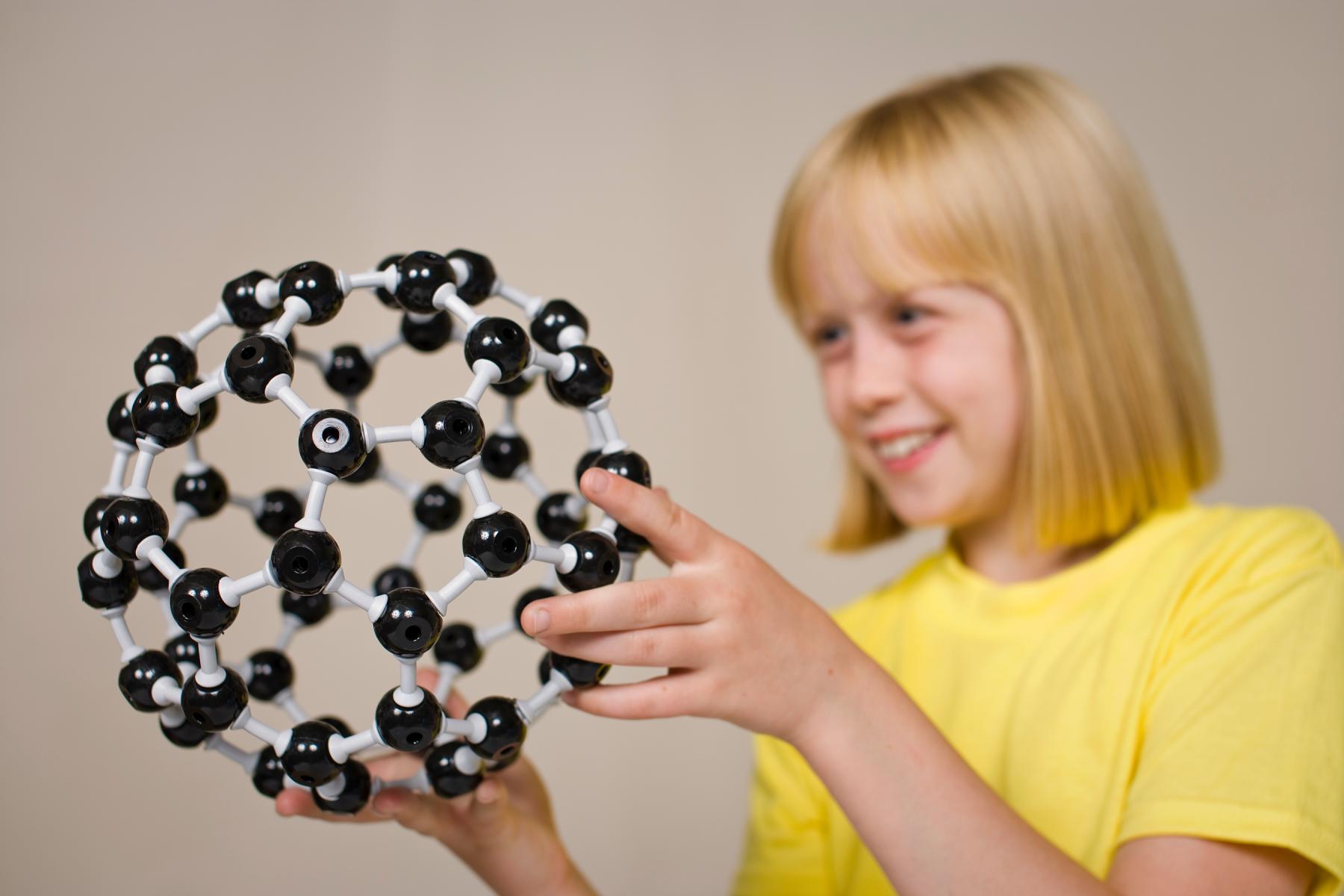 A girl looking at a model of a buckyball