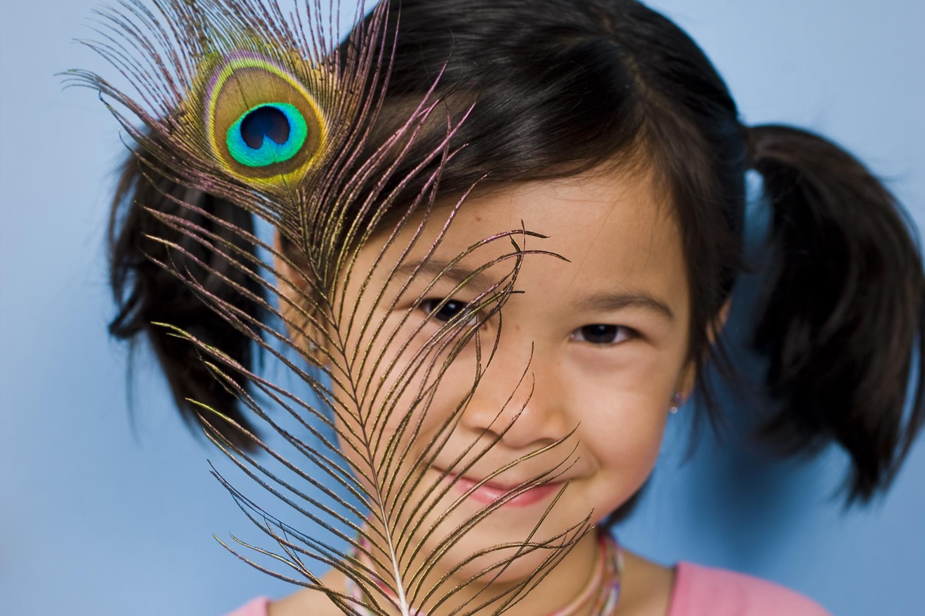 A girl with a peacock feather.