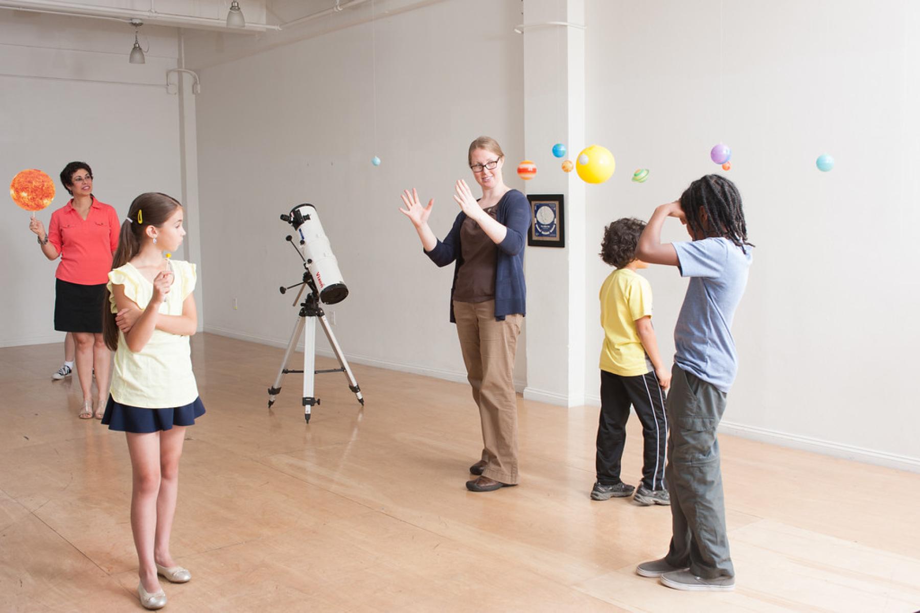 Facilitator standing in the middle of a room while learners are spaced out at different lengths