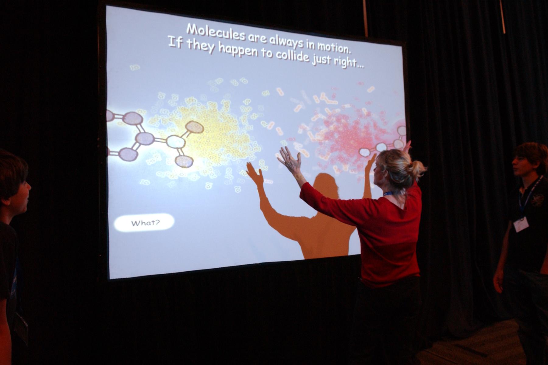 Mixing Molecules full body immersive exhibit with person in front of large screen 