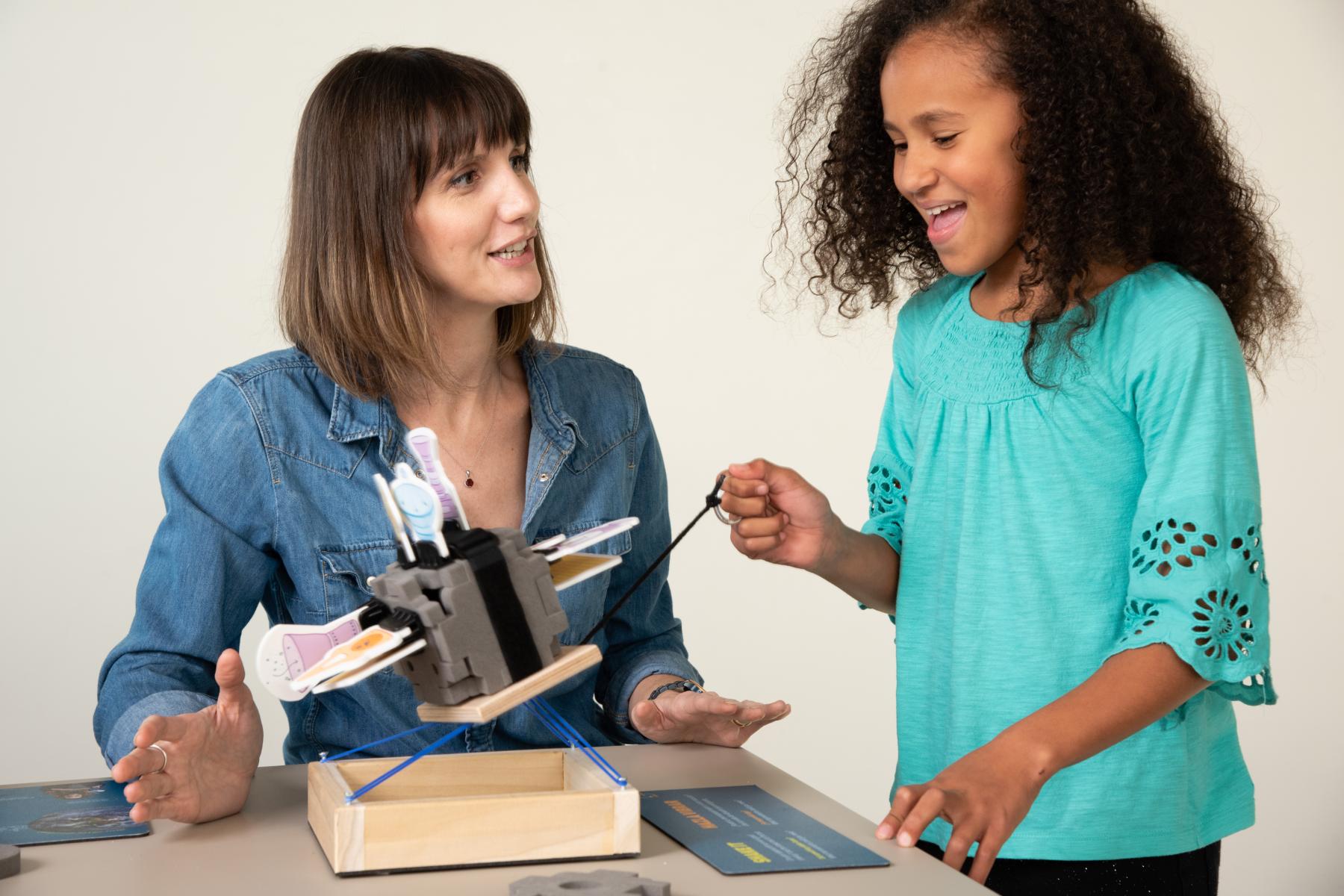 Facilitator and learner test the spacecraft model on the shake table