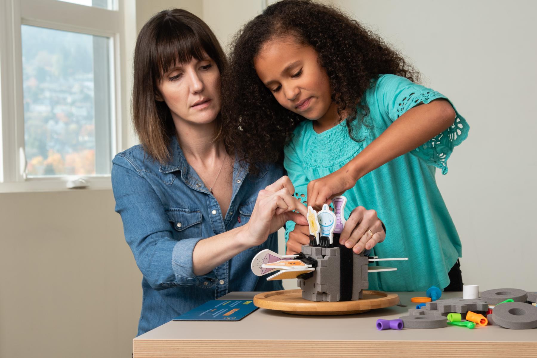 Facilitator and learner strap the spacecraft model to the spin table