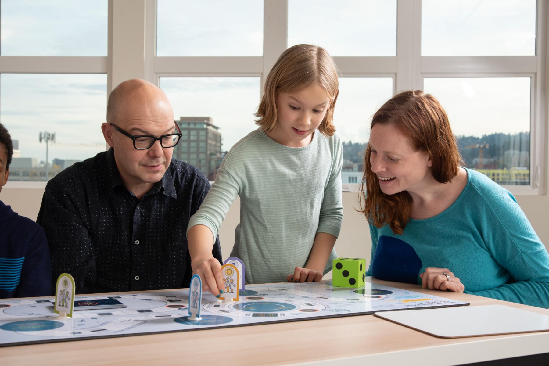 a family playing the mission to space board game moves a pawn on the board