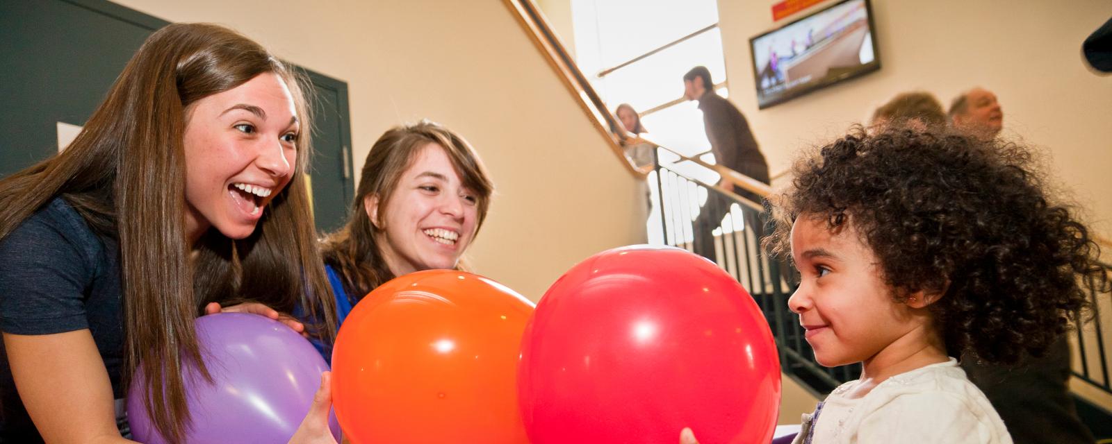 Learner smells balloons with educators