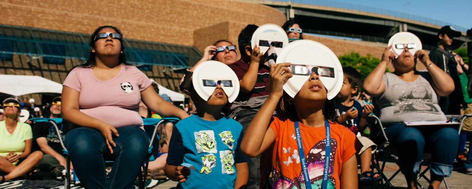 Family watching the solar eclipse safely