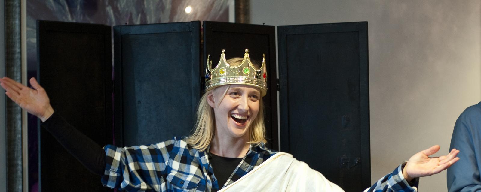 Woman dressed for theater play in crown and robe